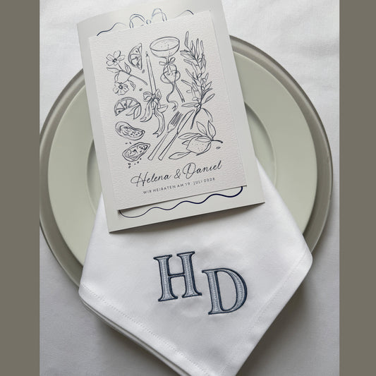 Bestickte Hochzeitsserviette mit Monogramm auf gedecktem Tisch
